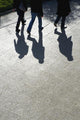 Pedestrians and their shadows on a walkway Wall Mural