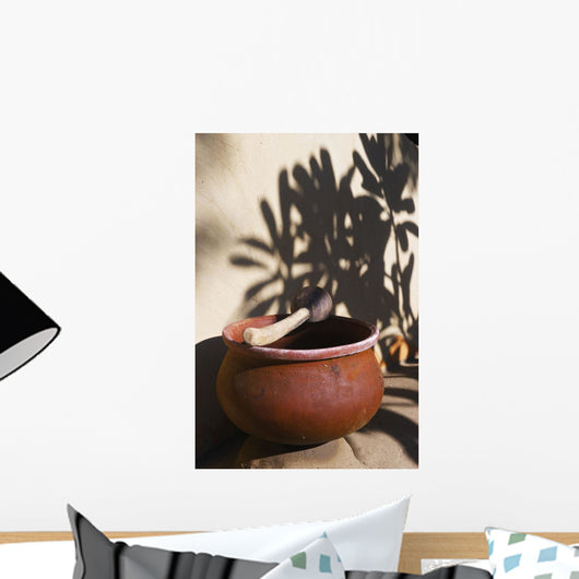 A clay bowl and wooden tool Wall Mural