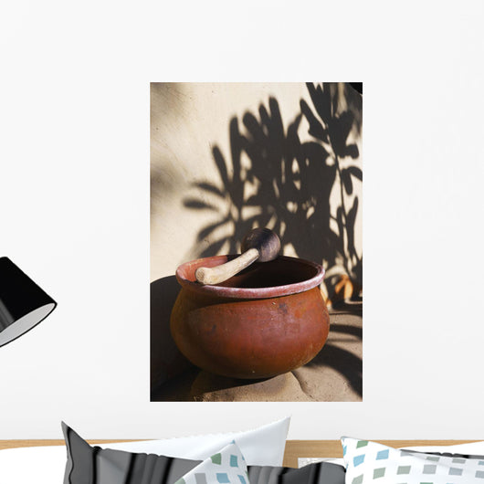 A clay bowl and wooden tool Wall Mural