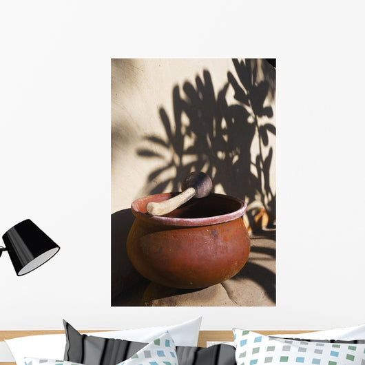 A clay bowl and wooden tool Wall Mural