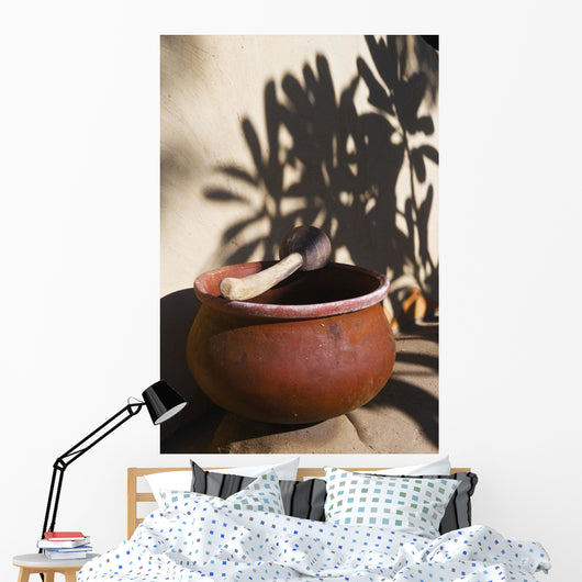 A clay bowl and wooden tool Wall Mural
