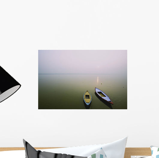 Two wooden boats sit on the tranquil water of the Ganges Wall Mural