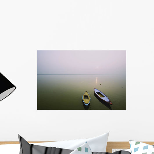 Two wooden boats sit on the tranquil water of the Ganges Wall Mural