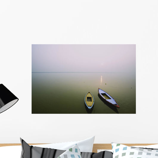 Two wooden boats sit on the tranquil water of the Ganges Wall Mural