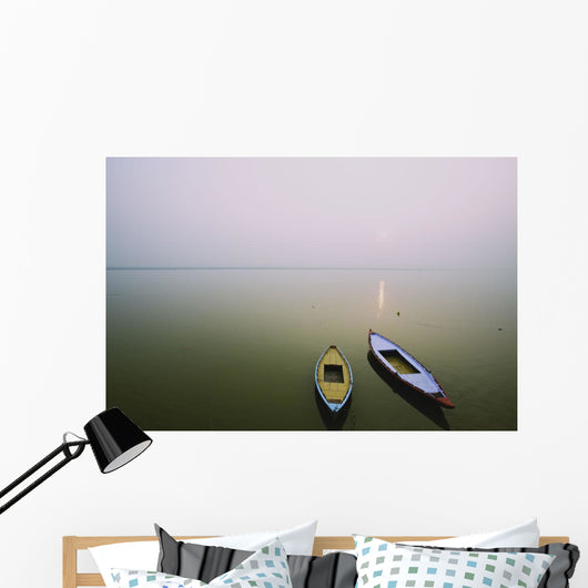 Two wooden boats sit on the tranquil water of the Ganges Wall Mural