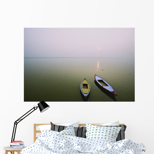 Two wooden boats sit on the tranquil water of the Ganges Wall Mural