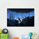 Gentoo Penguin leaping across rocks beneath wall of icicles Wall Mural