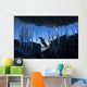 Gentoo Penguin leaping across rocks beneath wall of icicles Wall Mural
