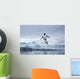 Gentoo Penguins leaping from water along Cuverville Island shoreline Wall Mural