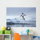 Gentoo Penguins leaping from water along Cuverville Island shoreline Wall Mural