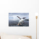 Gentoo Penguin leaping from ocean onto rocky shoreline near rookery Wall Mural