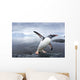 Gentoo Penguin leaping from ocean onto rocky shoreline near rookery Wall Mural