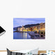 Buildings illuminated by lights along the water's edge at sunrise Wall Mural