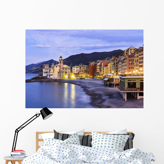Buildings illuminated by lights along the water's edge at sunrise Wall Mural
