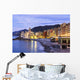 Buildings illuminated by lights along the water's edge at sunrise Wall Mural