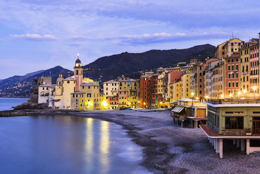 Buildings illuminated by lights along the water's edge at sunrise Wall Mural