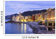 Buildings illuminated by lights along the water's edge at sunrise Wall Mural