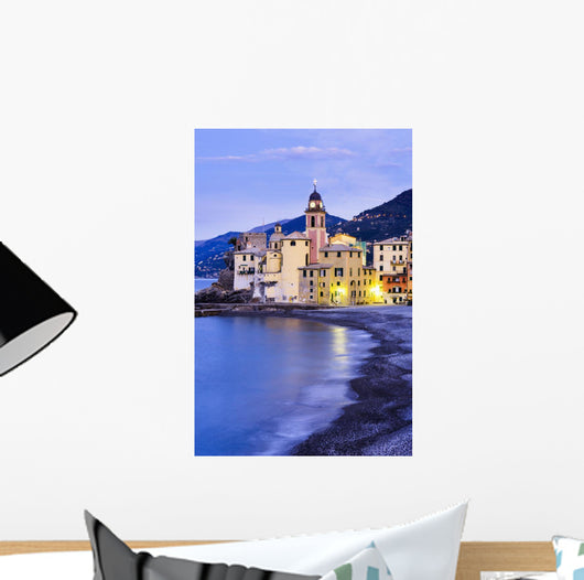 Buildings illuminated by lights along the water's edge at sunrise Wall Mural