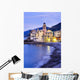 Buildings illuminated by lights along the water's edge at sunrise Wall Mural