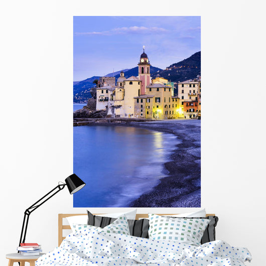 Buildings illuminated by lights along the water's edge at sunrise Wall Mural