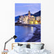 Buildings illuminated by lights along the water's edge at sunrise Wall Mural