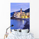 Buildings illuminated by lights along the water's edge at sunrise Wall Mural