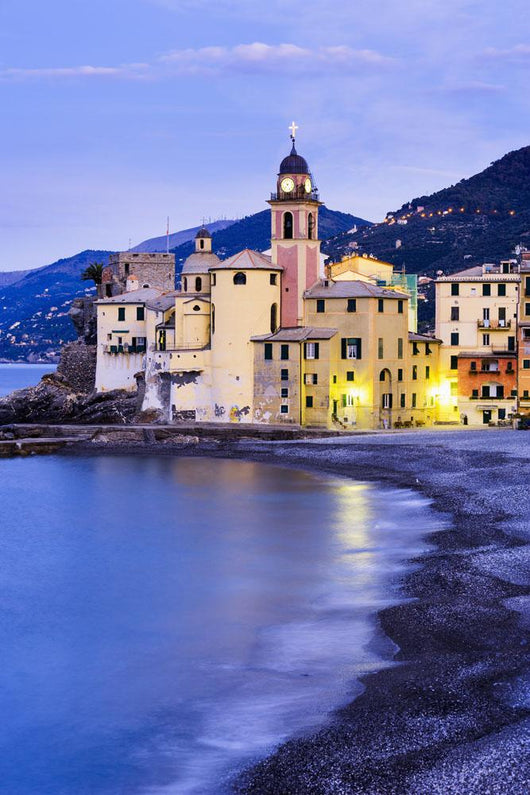 Buildings illuminated by lights along the water's edge at sunrise Wall Mural