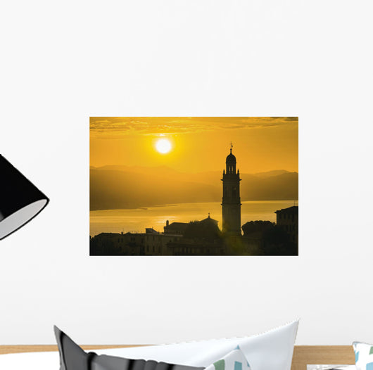 Golden sky at dusk with tower of church Wall Mural