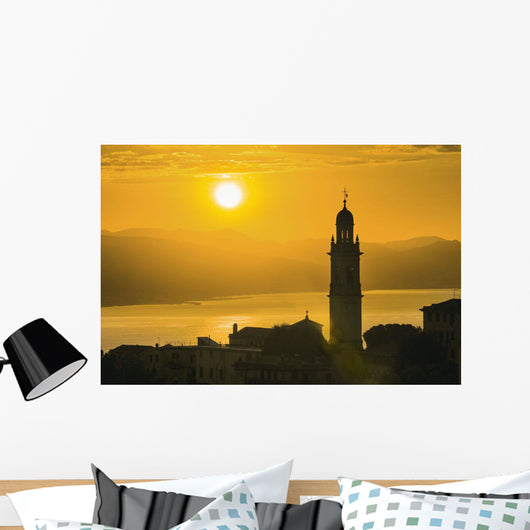 Golden sky at dusk with tower of church Wall Mural