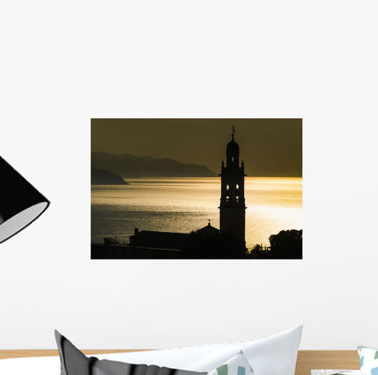 Golden sunlight reflected on water at dusk with tower of church Wall Mural