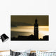 Golden sunlight reflected on water at dusk with tower of church Wall Mural