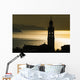Golden sunlight reflected on water at dusk with tower of church Wall Mural