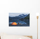 Man reading on a electronic tablet while camping with a tent and kayak Wall Mural