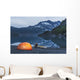 Man reading on a electronic tablet while camping with a tent and kayak Wall Mural