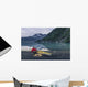 Man reading on a electronic tablet while camping with a kayak Wall Mural