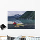 Man reading on a electronic tablet while camping with a kayak Wall Mural
