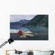 Man reading on a electronic tablet while camping with a kayak Wall Mural