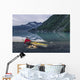Man reading on a electronic tablet while camping with a kayak Wall Mural