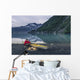 Man reading on a electronic tablet while camping with a kayak Wall Mural