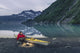 Man reading on a electronic tablet while camping with a kayak Wall Mural
