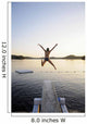 A swimmer jumps off a diving board as the sun sets over a lake Wall Mural