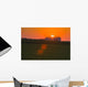 The sun sets behind a large commercial grain storage facility Wall Mural