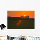 The sun sets behind a large commercial grain storage facility Wall Mural
