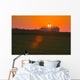 The sun sets behind a large commercial grain storage facility Wall Mural