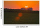 The sun sets behind a large commercial grain storage facility Wall Mural