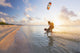Kiteboarding in tropical lagoon in the South Pacific at sunset Wall Mural