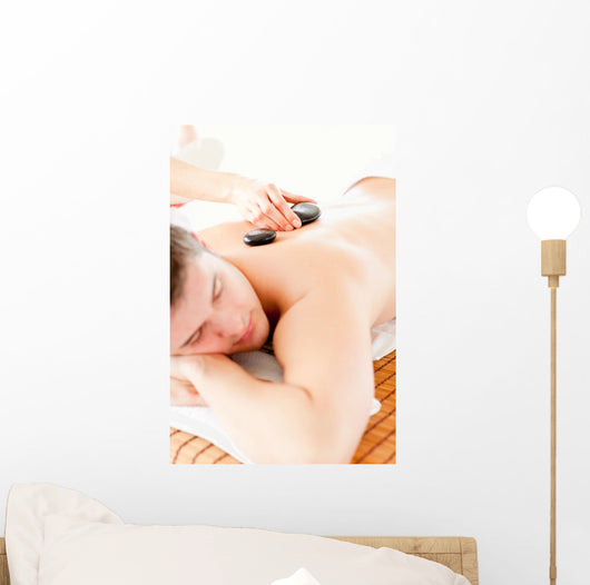 Relaxed Young Man Receiving a Back Massage with Hot Stone Wall Mural
