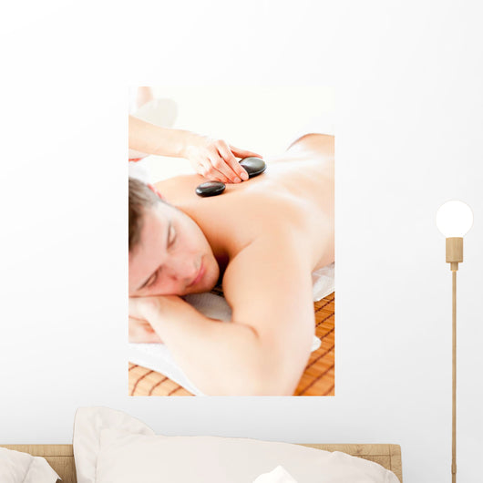 Relaxed Young Man Receiving a Back Massage with Hot Stone Wall Mural