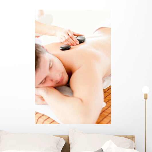Relaxed Young Man Receiving a Back Massage with Hot Stone Wall Mural