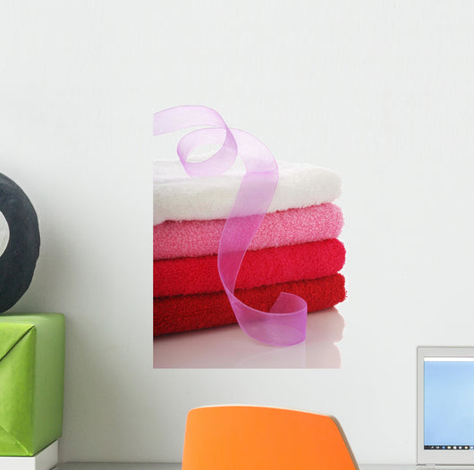 Stack of clean towels and pink ribbon Wall Mural